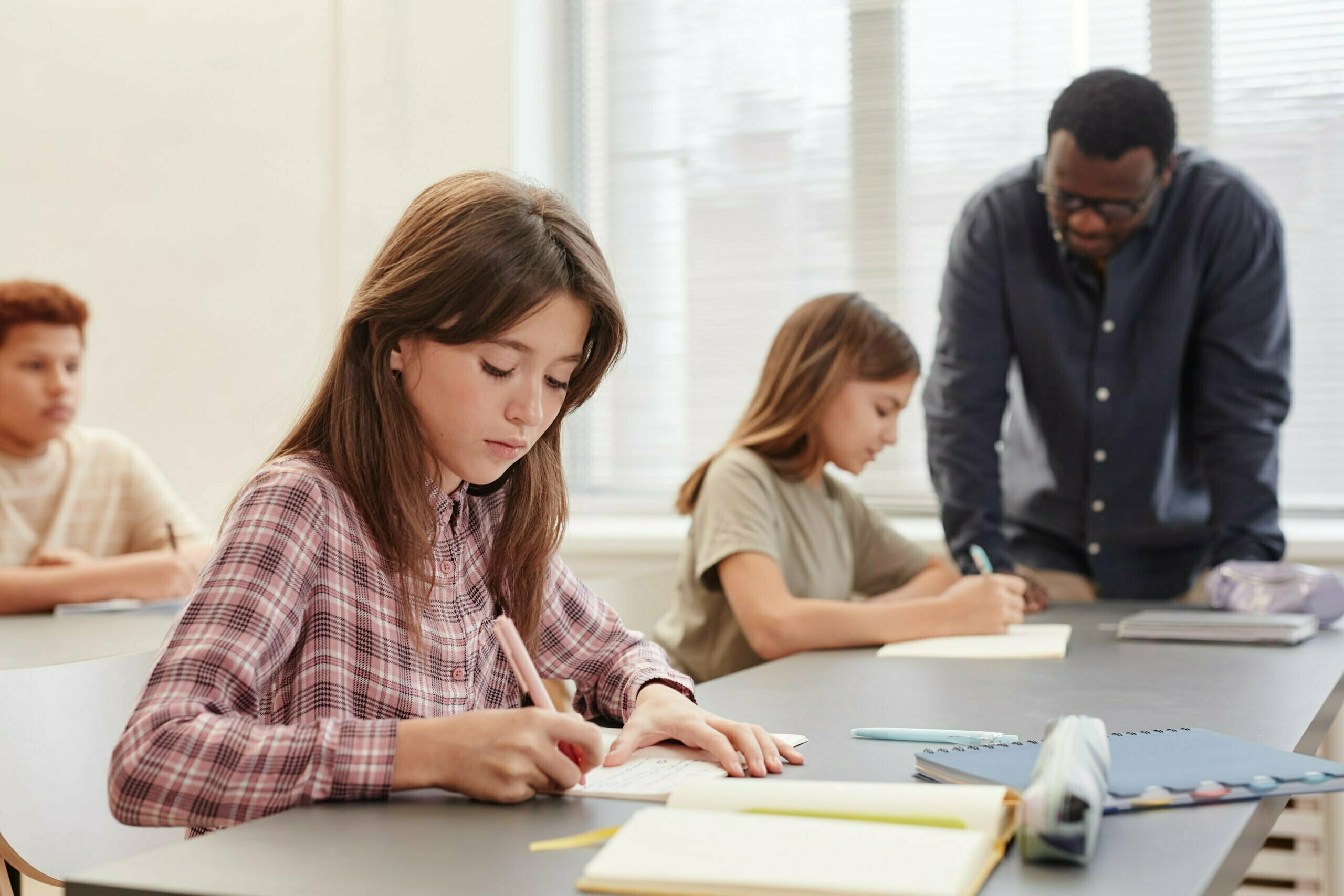 Student taking test in classroom illustrating how to do well in school.