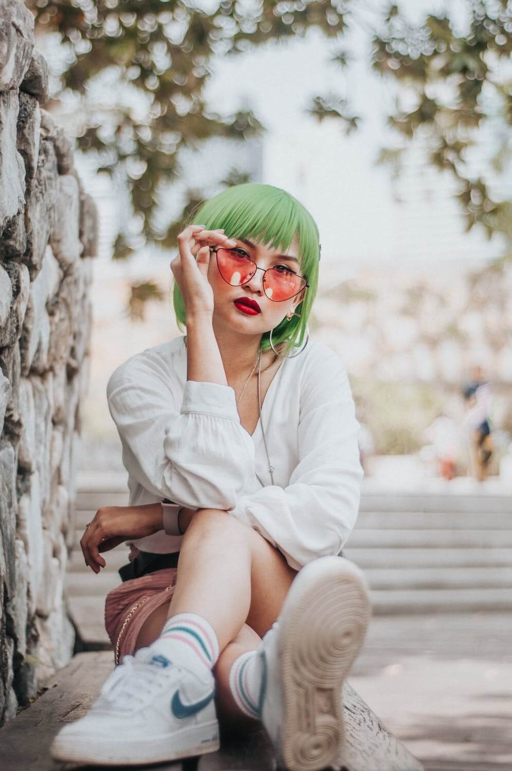 a woman wearing a green headband and sitting on a white bench