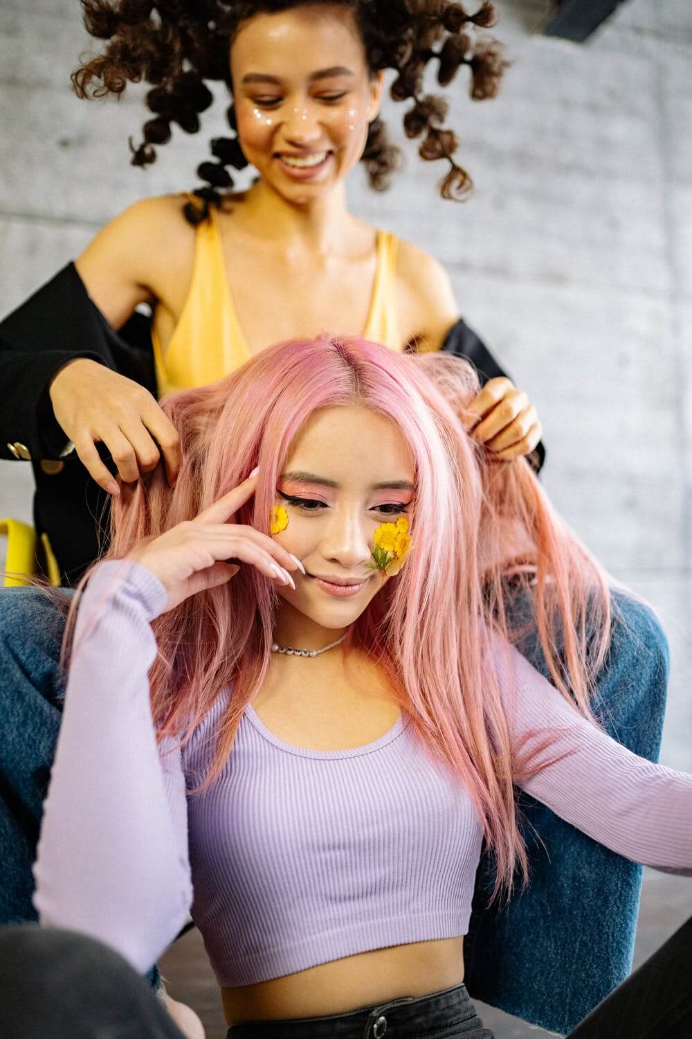 a woman with her hands on another woman's head