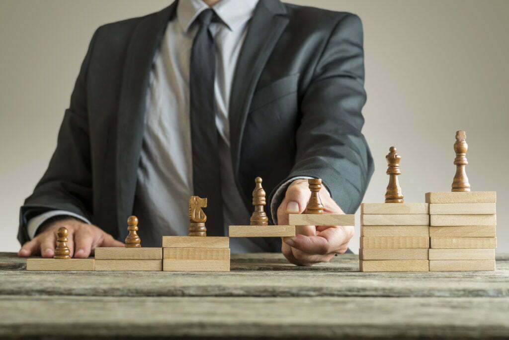 Man in suit strategizing with chess pieces representing career management and lifestyle choices.